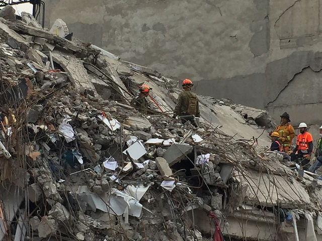 earthquke ruins and broken building with one rescuer
