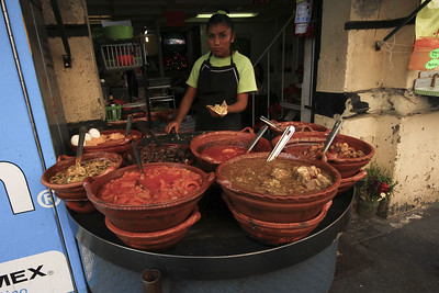 Mexican woman selling tacos de guisado