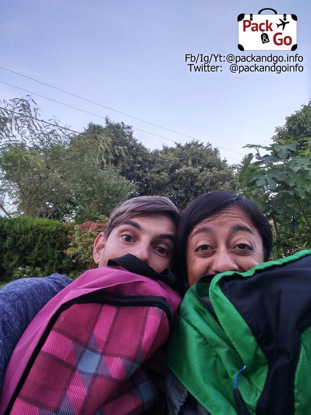 Two people hiding behind backpacks